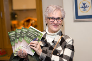 A woman holding up BIll's books